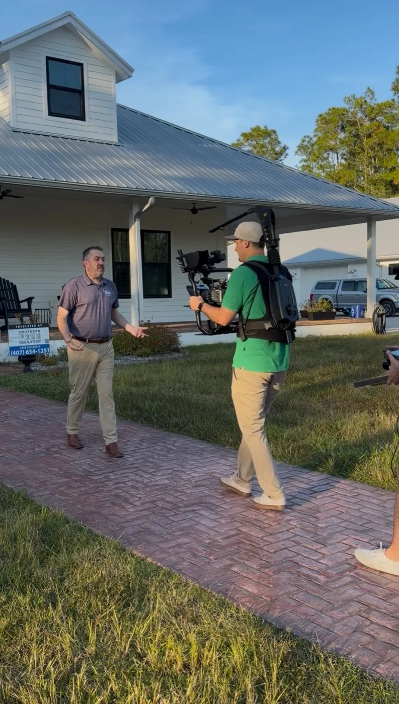 Ryan filming an interview with a gimbal-mounted camera outside a Florida home