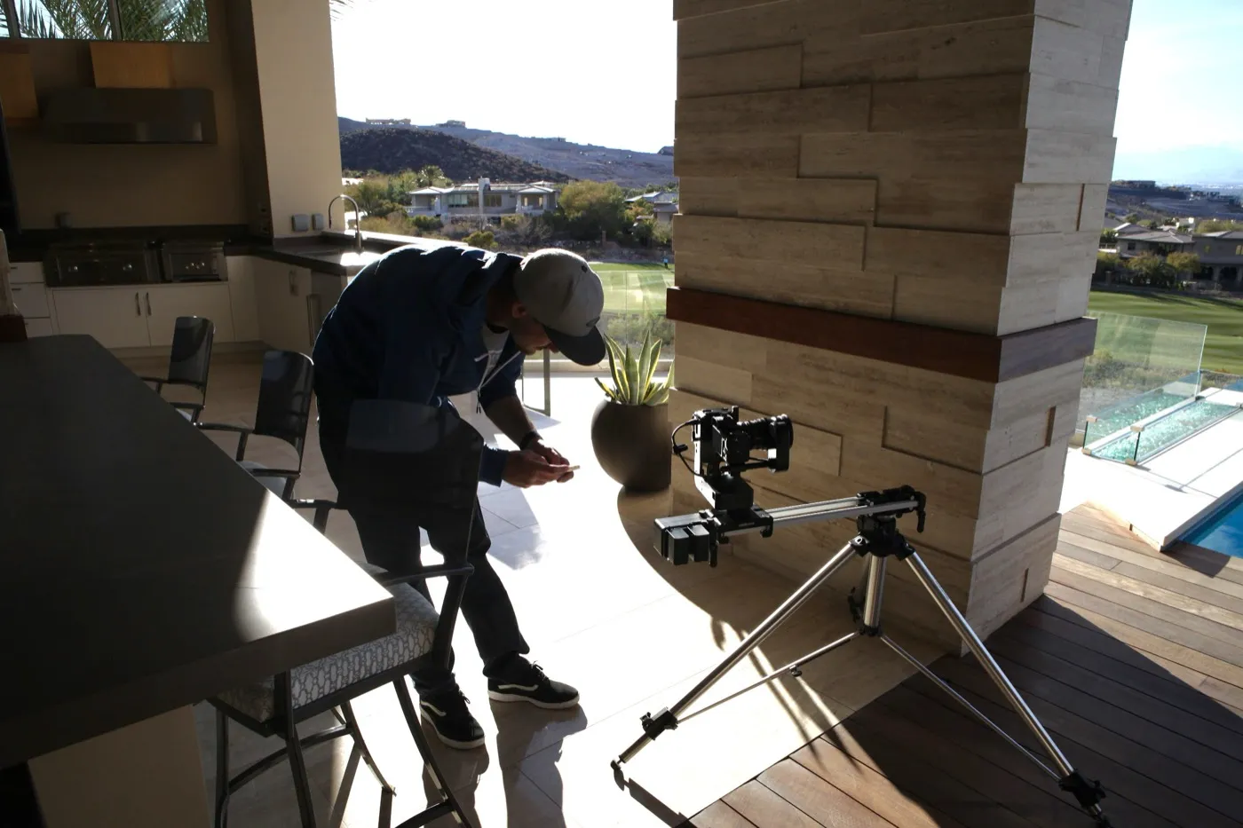 Camera set up on a slider on a hillside patio overlooking a desert golf course
