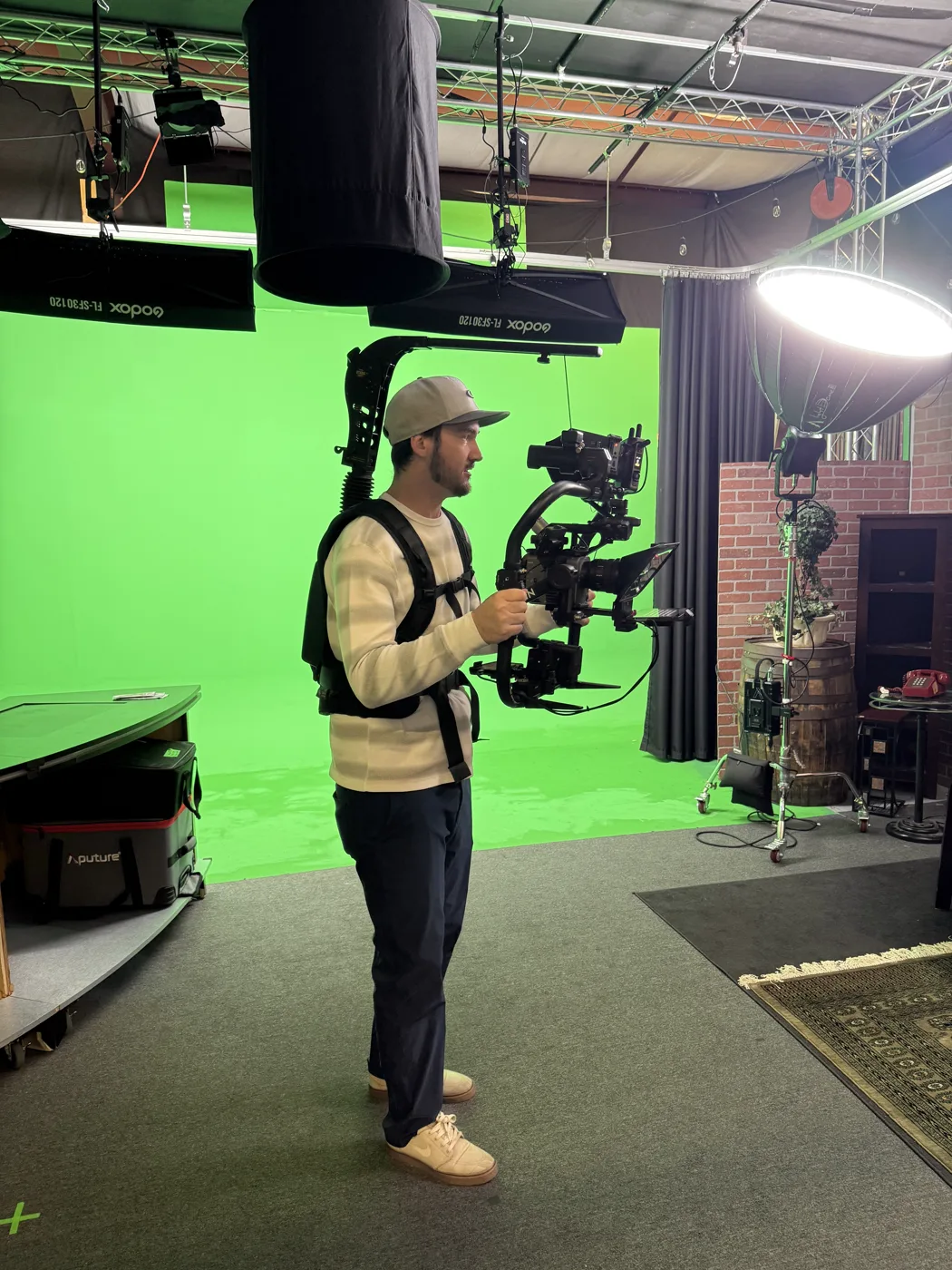 Ryan operating a stabilized camera rig on a green screen studio stage